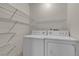 Functional laundry room with washer, dryer, and wire shelving for organization at 2124 Willowbury Dr # D, Las Vegas, NV 89108