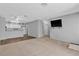 Bright and airy living room with plush carpet, laminate flooring, and mounted TV at 2124 Willowbury Dr # D, Las Vegas, NV 89108