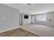 Bright living room with carpet, laminate flooring, mounted TV, and backyard access at 2124 Willowbury Dr # D, Las Vegas, NV 89108