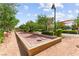 Outdoor bocce ball court with seating areas and lush greenery and landscaping in a beautiful community at 3058 Casarano Ct, Henderson, NV 89044