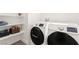 Convenient laundry room featuring modern washer and dryer, with shelving for storage at 3058 Casarano Ct, Henderson, NV 89044
