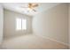 Bright bedroom with neutral carpet, ceiling fan, and a window with plantation shutters at 3405 Kingbird Dr, North Las Vegas, NV 89084