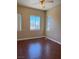 Bright bedroom with hardwood floors, a ceiling fan, and natural light from multiple windows at 3679 Funston Way, Las Vegas, NV 89129