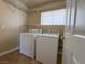 Functional laundry room featuring a washer, dryer, and shelving for storage at 3679 Funston Way, Las Vegas, NV 89129