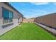 A well-maintained backyard features artificial turf, and a rock border against a block wall at 369 Old Erie Pl, Henderson, NV 89011