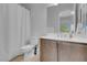 Bright bathroom featuring a shower with curtain, neutral walls, with a gray vanity and light-colored flooring at 369 Old Erie Pl, Henderson, NV 89011