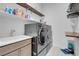 Functional laundry room featuring modern washer/dryer, sink with cabinets, and upper storage shelves at 369 Old Erie Pl, Henderson, NV 89011