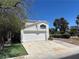 This is a two-story white home featuring a two-car garage and traditional desert landscaping in the front yard at 3929 Dream St, Las Vegas, NV 89108