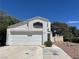 Two-story home featuring a white stucco exterior, attached two-car garage, and a well-manicured front yard at 3929 Dream St, Las Vegas, NV 89108