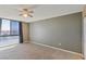 Neutral bedroom with ceiling fan, large window, and soft carpeting at 3930 University Center Dr # 804, Las Vegas, NV 89119