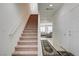 Welcoming hallway with a staircase leading to a brightly lit living area featuring neutral colors at 3949 Amanda Bay Ave, North Las Vegas, NV 89081