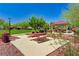 Community park featuring a picnic table, covered seating, grassy areas, and mature landscaping on a sunny day at 3949 Amanda Bay Ave, North Las Vegas, NV 89081