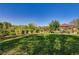 Grassy area with playground in a park featuring covered seating, mature trees, and well-maintained landscaping at 3949 Amanda Bay Ave, North Las Vegas, NV 89081