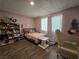 Bedroom with a pink comforter, desk area and laminated floors at 4823 El Tesoro Ave, Las Vegas, NV 89121