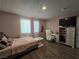Bedroom with a pink comforter, desk area and laminated floors at 4823 El Tesoro Ave, Las Vegas, NV 89121