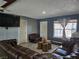 Open concept living room with a large leather couch and hard wood flooring at 4823 El Tesoro Ave, Las Vegas, NV 89121