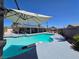 Inviting backyard pool area with a paddle board, lounge chairs, and shaded seating; perfect for outdoor relaxation at 4823 El Tesoro Ave, Las Vegas, NV 89121