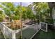 Beautiful backyard with lush trees, artificial grass, playset and lounge seating at 5486 Alfred Dr, Las Vegas, NV 89108