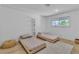 Minimalist bedroom with twin beds, a light rug, and shelving provides a simple and serene atmosphere at 5486 Alfred Dr, Las Vegas, NV 89108