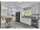 Kitchen featuring stainless appliances, white cabinets, breakfast bar, and beverage refrigerator at 5486 Alfred Dr, Las Vegas, NV 89108