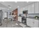 Kitchen with stainless appliances, white cabinets, brick accent wall, and modern countertops at 5486 Alfred Dr, Las Vegas, NV 89108
