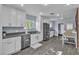 Bright kitchen with stainless appliances, white cabinets, modern countertops, and wood-look floors at 5486 Alfred Dr, Las Vegas, NV 89108