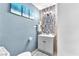 Stylish powder room with blue walls, tiled accent wall, and modern fixtures at 5612 Royal Castle Ln, Las Vegas, NV 89130