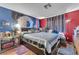 Bedroom with bold blue and red accents, decorative wall hangings, and wood laminate flooring at 5612 Royal Castle Ln, Las Vegas, NV 89130