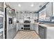 Updated kitchen featuring stainless steel appliances, gray cabinets, and stylish flooring at 5612 Royal Castle Ln, Las Vegas, NV 89130