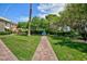 Green backyard lawn with a brick walkway leading to a pool at 572 Tam O Shanter, Las Vegas, NV 89109