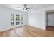 Bright bedroom with a ceiling fan, wood-look flooring, and sliding closet doors, opening to a small private balcony at 572 Tam O Shanter, Las Vegas, NV 89109