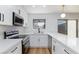 Contemporary kitchen features white quartz counters, stainless steel appliances and modern black fixtures at 572 Tam O Shanter, Las Vegas, NV 89109