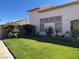 Lush, green backyard featuring a well-maintained lawn, privacy wall with bougainvillea, and garden space at 6363 Berry Patch Way, Las Vegas, NV 89142