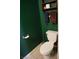 This half bathroom features green walls, a toilet, and a towel rack at 6363 Berry Patch Way, Las Vegas, NV 89142
