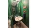 Stylish powder room with green textured walls, unique mirror, and compact vanity at 6363 Berry Patch Way, Las Vegas, NV 89142