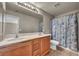 Bathroom features a double sink vanity, tiled floors and a shower with a themed shower curtain at 6377 W Haleh Ave, Las Vegas, NV 89141