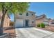 Daytime image of a two-story home with desert landscaping and a concrete driveway under a clear sky at 6377 W Haleh Ave, Las Vegas, NV 89141