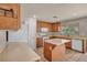 The kitchen has wood cabinets, a kitchen island, and appliances providing a functional space for cooking and meal preparation at 6377 W Haleh Ave, Las Vegas, NV 89141