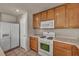 Cozy kitchen with white appliances, wood cabinets and tile flooring at 6377 W Haleh Ave, Las Vegas, NV 89141