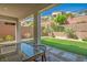Covered patio with outdoor dining space and view of the backyard's turf and retaining wall at 6433 Farness St, Las Vegas, NV 89135