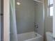 Bright bathroom featuring a tub with gray tiling, a shower head, and a curtain at 6433 Farness St, Las Vegas, NV 89135
