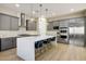 Modern kitchen with gray cabinets, stainless steel appliances, island with seating, and stylish pendant lighting at 6433 Farness St, Las Vegas, NV 89135