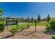 Community dog park with a metal fence, shade, and plenty of green space for dogs to play at 6953 Midnight Bronze St, North Las Vegas, NV 89086