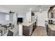 Open floor plan with kitchen, featuring stainless appliances, and living area with comfortable seating at 6953 Midnight Bronze St, North Las Vegas, NV 89086