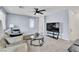 Cozy living room with a comfortable couch, ceiling fan, and a modern entertainment center at 6953 Midnight Bronze St, North Las Vegas, NV 89086