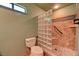 Bathroom showcases shower with glass blocks, pebble floor, grab bar, and tile surround at 7100 Carrondale Way, Las Vegas, NV 89128