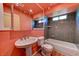 Unique full bathroom features a pedestal sink, tile walls, and a shower over tub at 7100 Carrondale Way, Las Vegas, NV 89128