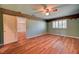 A brightly-lit bedroom features hardwood floors, a window with shutters and ceiling fan at 7100 Carrondale Way, Las Vegas, NV 89128