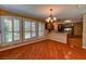 Open dining room with hardwood floors, chandelier and plantation shutters adjacent to the kitchen at 7100 Carrondale Way, Las Vegas, NV 89128
