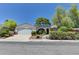 Inviting single-story home featuring mature landscaping, a two-car garage, and solar panels at 7100 Carrondale Way, Las Vegas, NV 89128